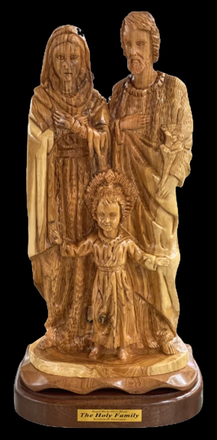 Olive wood carving of Joseph and Mary standing with the child Jesus in front of them
